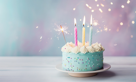Pastel birthday cake with three birthday candles and sparkler