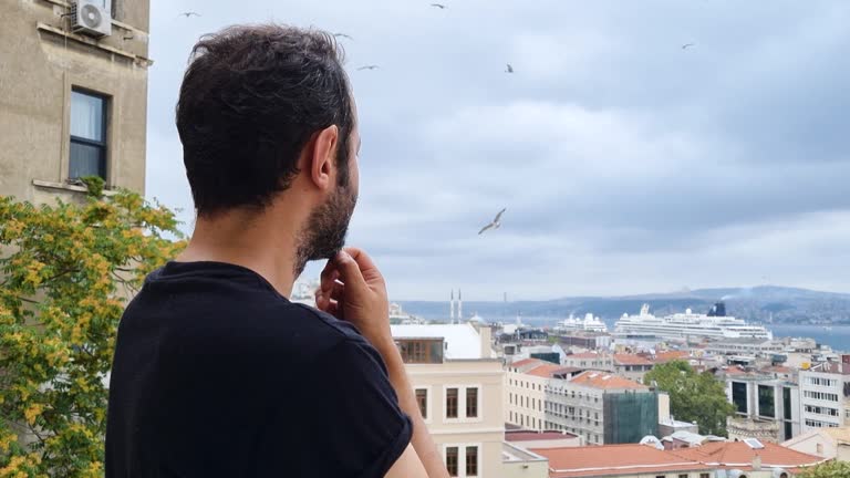 The man stands on the balcony looking view