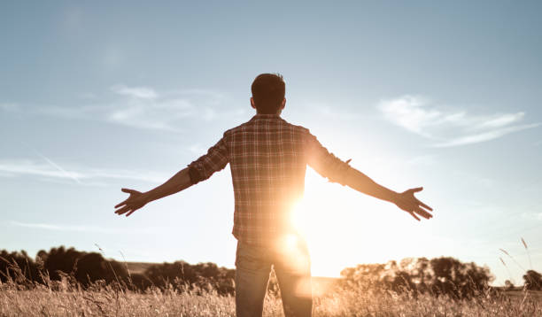 istock Young man facing sunset rejoices, enjoys life. 1619244028