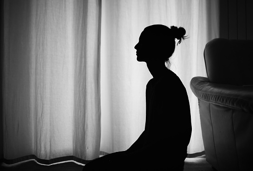 Silhouette portrait of a young woman on black background