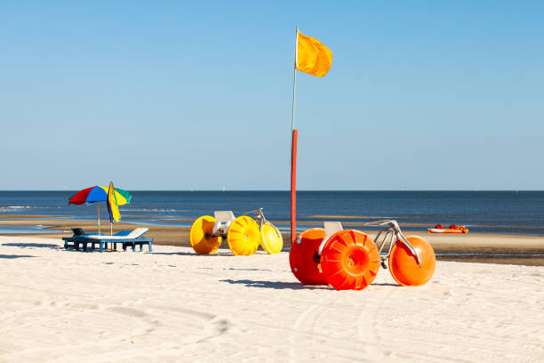 Gulf coast beach in Biloxi, Mississippi with water tricycles and lounge chairs.