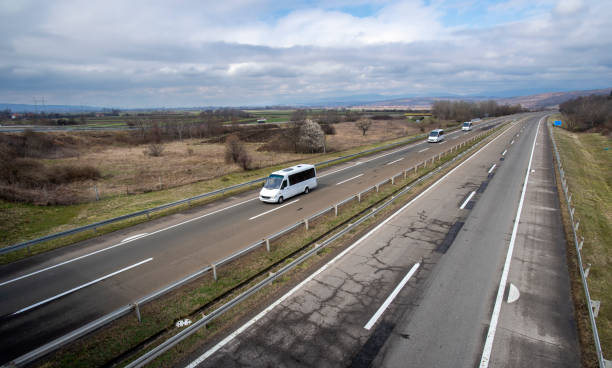 small modern comfortable tourist bus driving on the highway. the concept of travel and bus tourism. - delivery van imagens e fotografias de stock