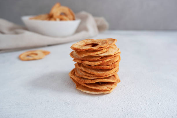 istock Apple chips, dried apple slices. Organic apple chips on a light background. dehydrated apple chips. 1619259861