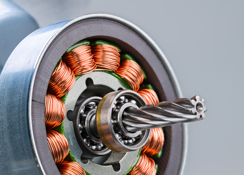 Copper wire winding on electromagnetic coils with metal sheets inside steel bushing of electrical engine