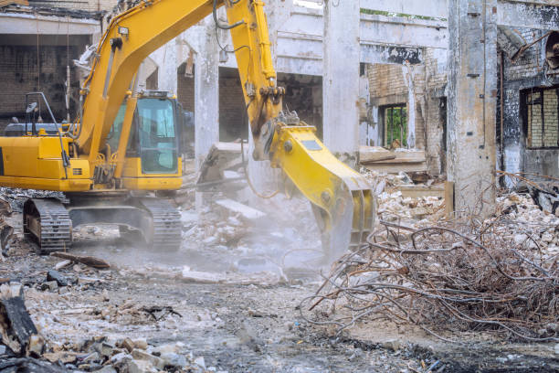 istock Steel hydraulic attachment pliers on excavator grappling construction debris in collapsed industrial building 1619272309