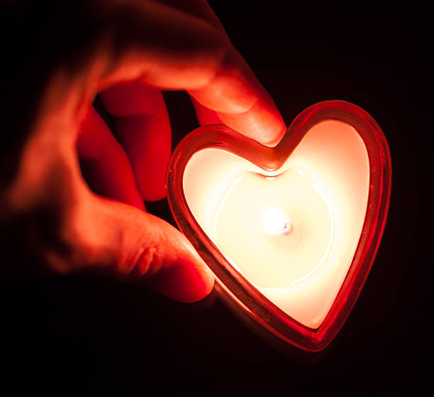 istock hand holding burning candle heart 161928860