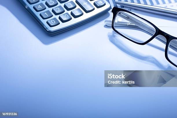 Partial View Of A Calculator And Glasses On A White Desk Stock Photo - Download Image Now