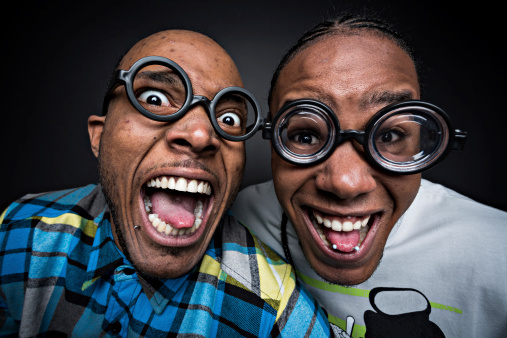 Happy nerds with glasses, over black background.