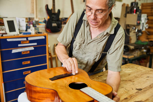 istock Luthier cleaning an acoustic guitar in a workshop 1619339887