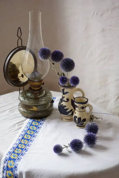 Rustic arrangement with gas lamp, romanian ceramics and glandular globe-thistles