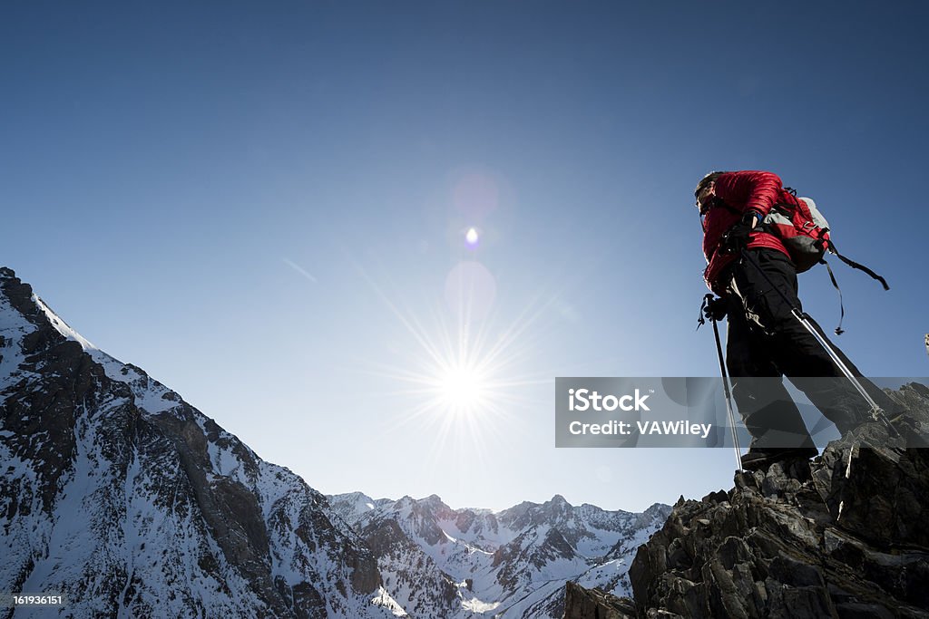 awe A hiker in the mountains watching the sun go down  Achievement Stock Photo