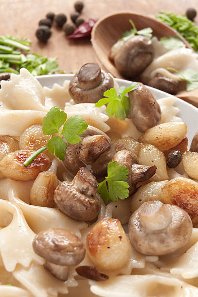 Pasta with grilled mushrooms and onions Pasta with grilled mushrooms and onions with spice, fresh parsley and onions. Ukranian food cooked selective focus vertical pasta stock pictures, royalty-free photos & images