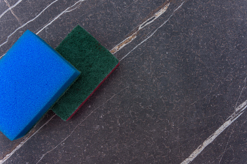 Two cleaning sponges on a marble background