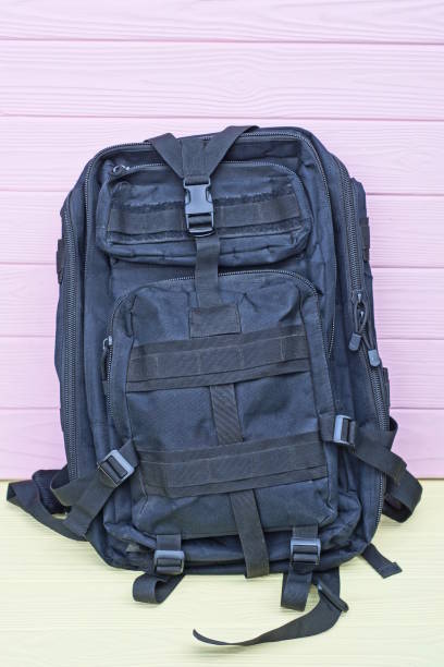 istock one large army black backpack stands on a yellow wooden table 1619446661