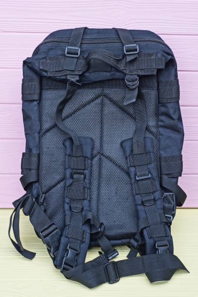 istock one large army black backpack stands on a yellow wooden table 1619446662