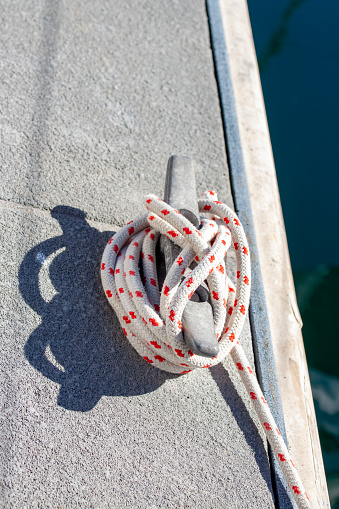 Cleat and rope, background with copy space, vertical composition