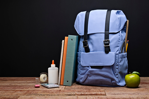 Photo of Back to School Backpack and Supplies with a blank black chalkboard background