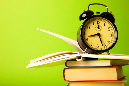 Alarm Clock and books on the green background