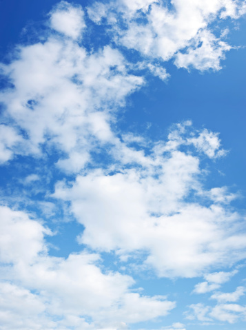 Blue sky with fluffy clouds wide background. Panoramic summer banner with bright sky and white clouds
