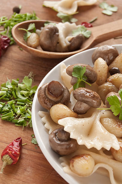 Pasta with grilled mushrooms and onions Pasta with grilled mushrooms and onions with spice, fresh parsley and onions. Ukranian food cooked selective focus vertical pasta stock pictures, royalty-free photos & images