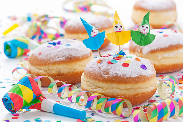 Homemade Bugnes are little golden doughnuts sprinkled with icing sugar, sweet and crispy, prepared for Mardi gras . Served in a jar with colored paper napkin, confetti and colombina carnaval masks in the background