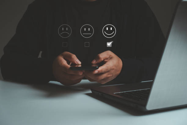 istock Customer service evaluation concept, Good feedback, Best review. Business people use a smartphone and he is pressing a face emoticon smiling in satisfaction on the virtual touch screen. 1619521275