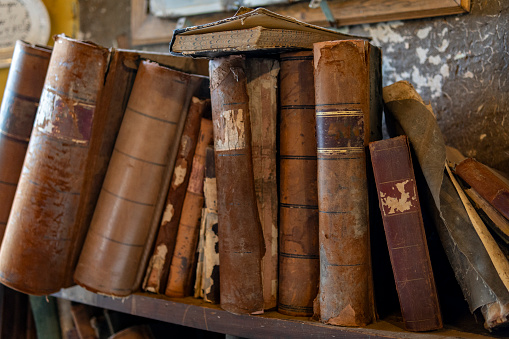 High angle view of an open old book with empty pages shot on dark rustic wooden table. Useful copy space available for text and/or logo on the pages and at the right of the book. Predominant color is brown. High resolution 42Mp studio digital capture taken with Sony A7rII and Sony FE 90mm f2.8 macro G OSS lens