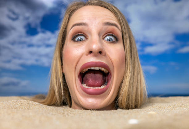 Portrait of attractive blonde woman lying on sandy beach relaxing during summertime