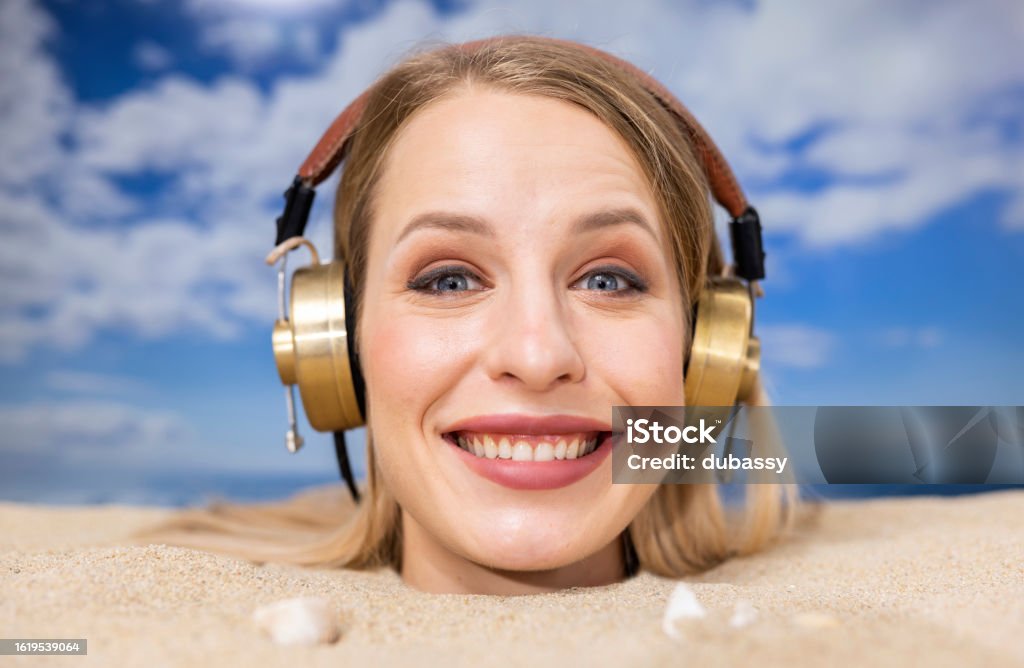 Woman Buried In Sand On Beach With Headphones Stock Photo - Download ...