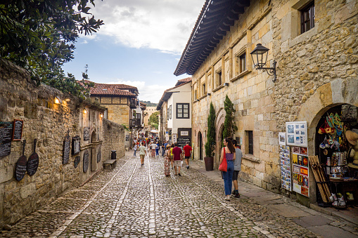 Tourist Couple Walking through a Cobbled Street of the Medieval Town of Santillana del Mar