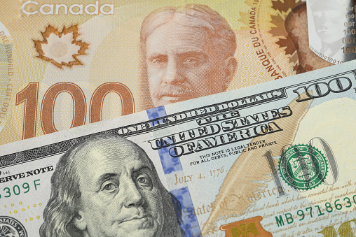 Closeup of US 100 dollar bill and Canadian 100 dollar bill.