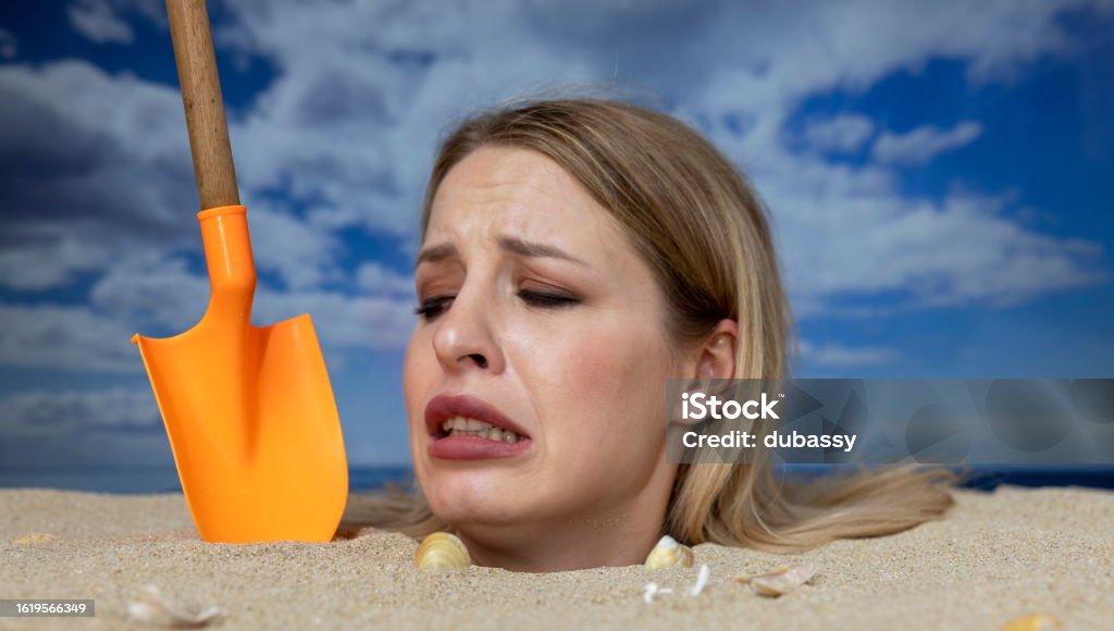 Woman Buried In Sand On Beach With Gun Stock Photo - Download Image Now ...