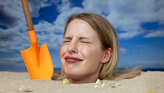 Woman Buried In Sand On Beach With Gun Stock Photo - Download Image Now ...