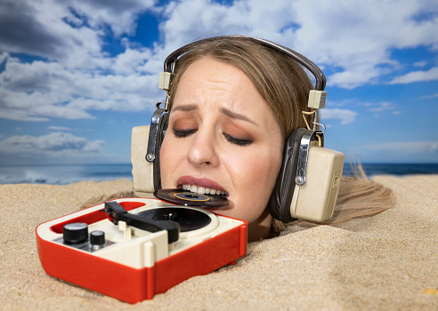 Woman Buried In Sand On Beach With Record Player Stock Photo - Download ...