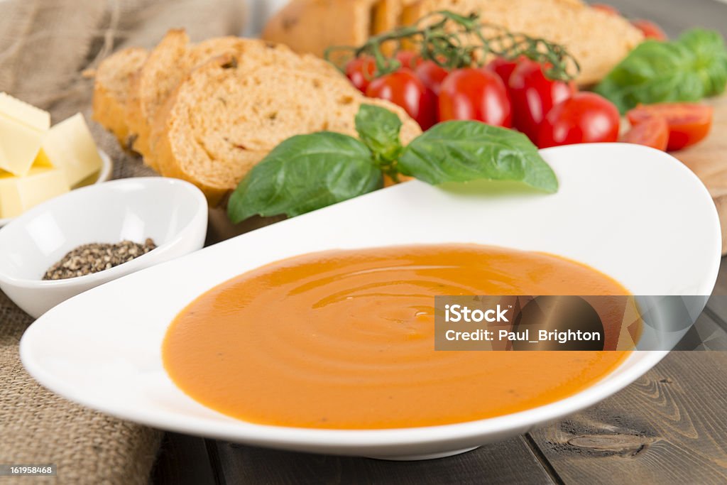 Cream of Tomato Soup Cream of tomato soup garnish with basil, with cracked black pepper, croutons and butter on the background. Appetizer Stock Photo