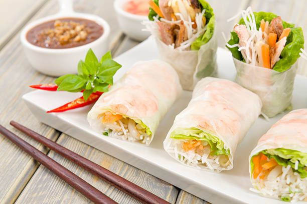 Goi cuon rolls on white plate with sauces and chopsticks Vietnamese fresh summer rolls filled with prawns, pork, herbs, rice vermicelli and vegetables served with hoisin and peanut dip and nouc mam cham. hoisin sauce stock pictures, royalty-free photos & images