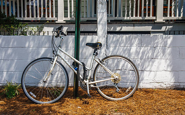 istock Old White Bicycle Chained to Green Pole 161960058