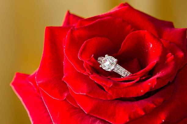 Closeup of Wedding Ring on Bouquet.Diamond engagemnet ring on Flower Background