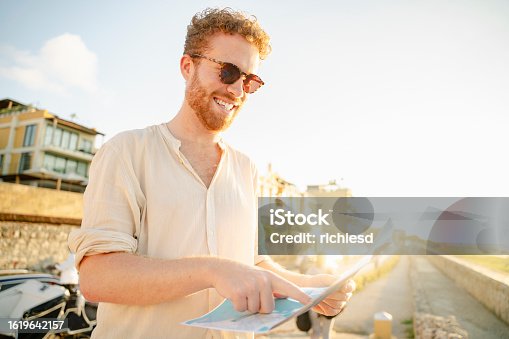 istock A young man looking at the map trying to find some tourist places in Cartagena stock video 1619642157