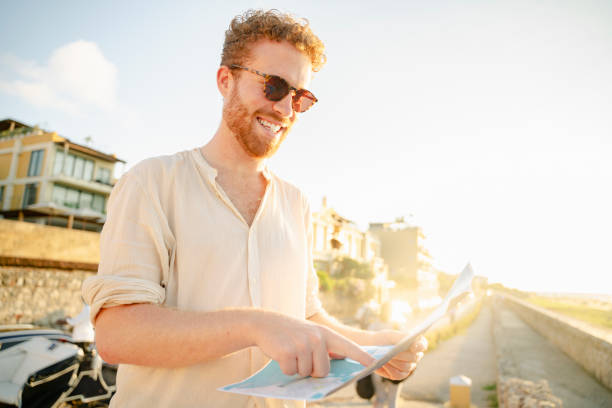 A young man looking at the map trying to find some tourist places in Cartagena stock video stock photo