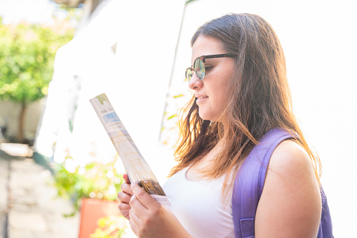 A young woman looking at the map trying to find some tourist places in Honda, Tolima - Colombia