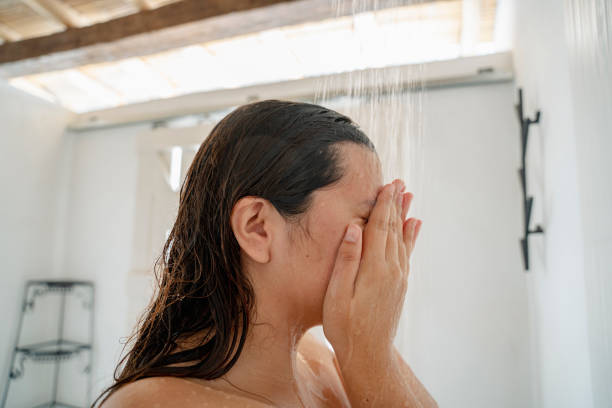 A young woman taking a shower in a hotel stock photo