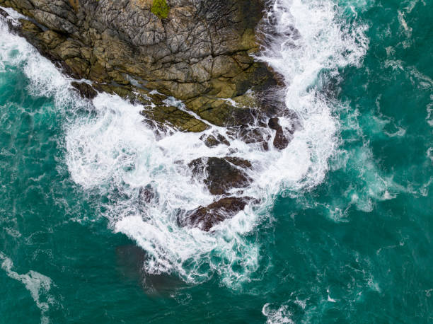 istock Waves crashing on seashore rocks,Top view sea surface waves background 1619697418