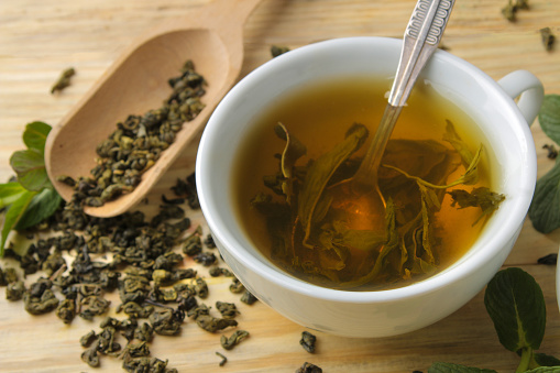 Green tea. Hot tea in a cup close-up on a wooden background