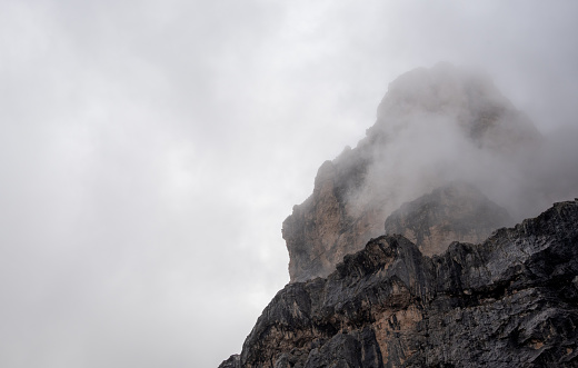 Cloudy fogy sky mountain peaks covered in mist in the morning. Dolomite rocky mountains , Italian alps