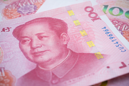 Chairman Mao (Mao Zedong) portrait on red 100 Chinese paper currency Yuan renminbi banknotes background. China or economy of Asia slow growth, global financial business, US trade war, Forex trading concept.