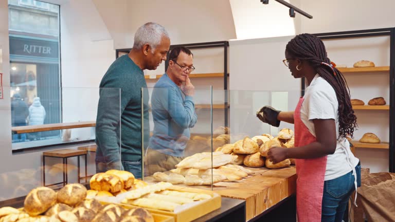 Old Male Friends Picking Bread from the Counter