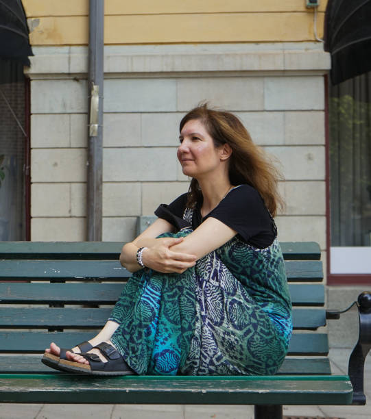 istock a woman sitting on a bench 1619811382