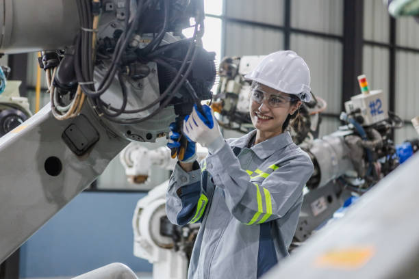 istock Engineers woman maintenance robotic arm. Female technician industrial checking robot machine. Futuristic industry production manufacturing. 1619820452