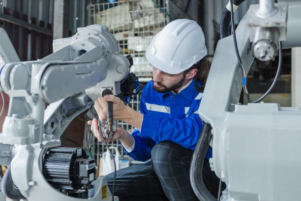 istock Male technician engineer checking automation robotics arm at industrial modern factory. man working at factory innovation automation robot. Maintenance department, robots used in industrial. 1619828093